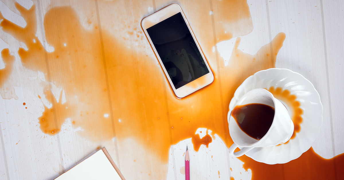 Lær hvad IP-certificering betyder En telefon på et skrivebord med kaffe spildt over den