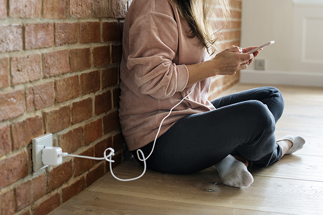 Lad din telefon op på den bedste måde Kvinde med telefon, der lader op