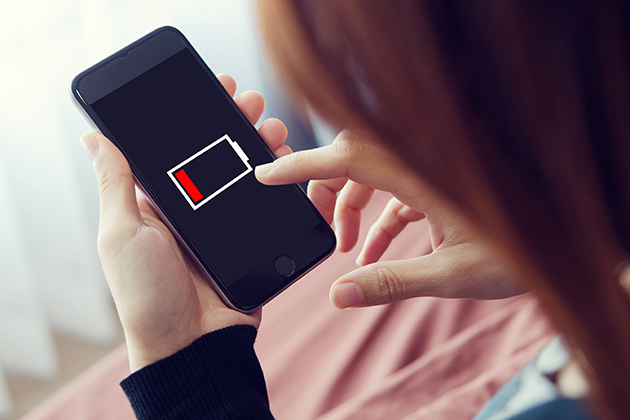 Spar på batteriet med strømbesparende tilstand Kvinde med telefon, der næsten er tør for strøm