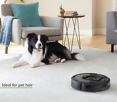 Roomba i7 Plus opsamler op til 99 % af allergenerne fra pollen, mug, støvmider samt kæledyrshår Billede af Roomba i7 Plus i en stue med en hund: Opsamler flere kæledyrshår end nogen anden robotstøvsuger