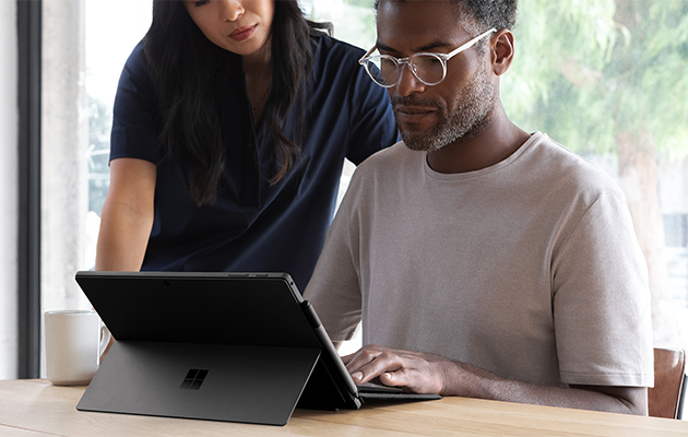 Hurtig opladning En mand og en kvinde arbejder på en Surface Pro
