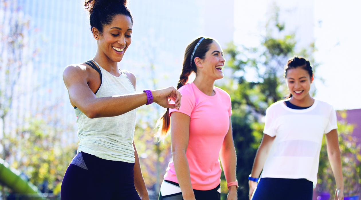 Fitbit sportsure og aktivitetsmålere Tre kvinder, der strækker ud efter træning med Fitbit Charge 3 på deres håndled