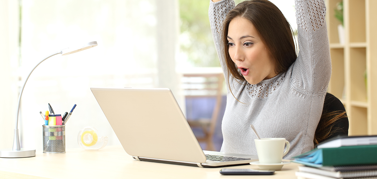 En god internetforbindelse er vigtig for dit smart home En glad kvinde rækker overrasket sine hænder i vejret foran en laptop
