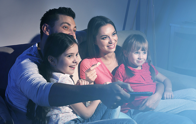 Der er ikke brug for fjernbetjeningen mere Billede af en familie, som sidder i en sofa