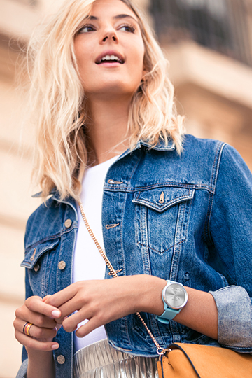 Pulstracking på dit håndled En kvinde i en denim-jakke og med et Vivomove HR ur på.