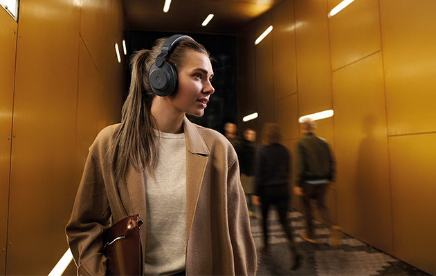 Aktiv støjreduktion er en teknologi hvor høretelefonerne udsender modsignaler mod støj i omgivelserne så det udlignes Kvinde med Jabra Elite 85h