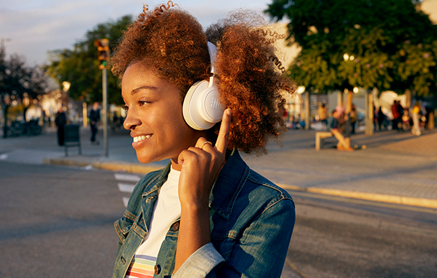 De trådløse hovedtelefoner JBL LIVE500BT kommer med JBLs signaturlyd med forstærket bas Hvide JBL Live-hovedtelefoner i ørerne på kvinde
