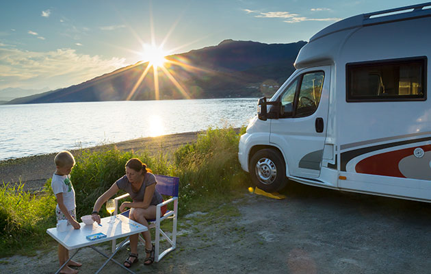 Madlavning kan være en udfordring på campingferien Autocamper ved vandet med mor og søn i solnedgang