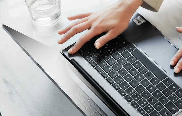 Fingeraftrykslæser En kvinde bruger fingeraftrykslæseren i power-knappen på en MateBook 13