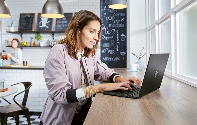 HP Envy x360 - Et flot design Kvinde bruger HP Envy x360 på en kaffebar