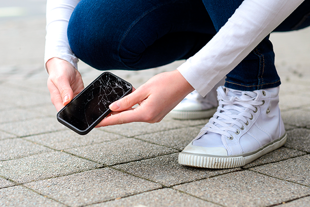 Det er let at komme til at tabe sin telefon Person holder ødelagt telefon