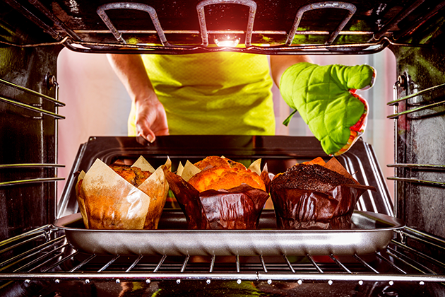 Det kan være smart at få hjælp over telefonen Kvinde tager muffins ud af ovnen