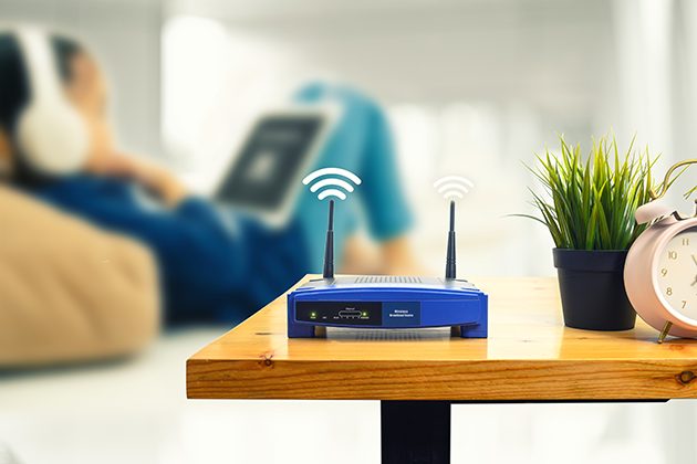Placér routeren central i hjemmet Barn sidder i stue med router i forgrunden
