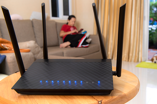 Tykke vægge dæmper wi-fi-signalet Pige sidder i stue med router i forgrunden