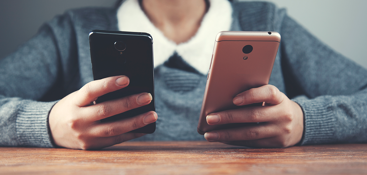 At skifte telefon behøver ikke være besværligt Kvinde sidder med to telefoner