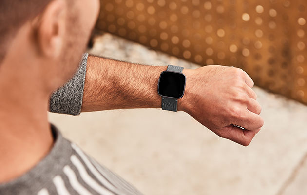 Fitbit Versa 2 er vandtæt ned til 50 m, så du kan trygt bruge det i poolen, i bruseren, på stranden og mere Mand med fokus på armen med Versa 2