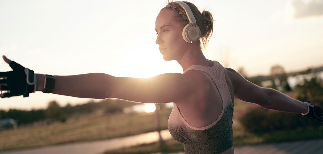 Vælg det rigtige sportsur til din træning og lyt musik uden telefon Kvinde i yoga-position med sportsur på håndleddet