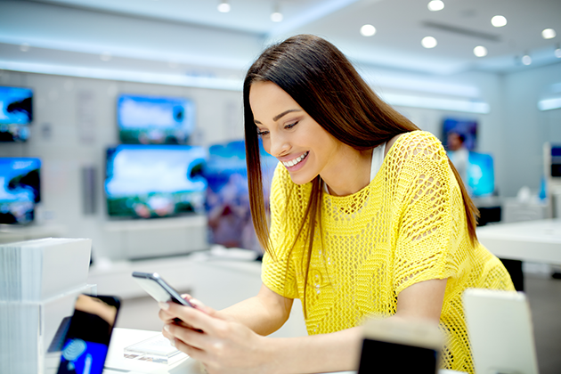 Skift fra Android-telefon til Android-telefon Smilende kvinde kigger på sin telefon