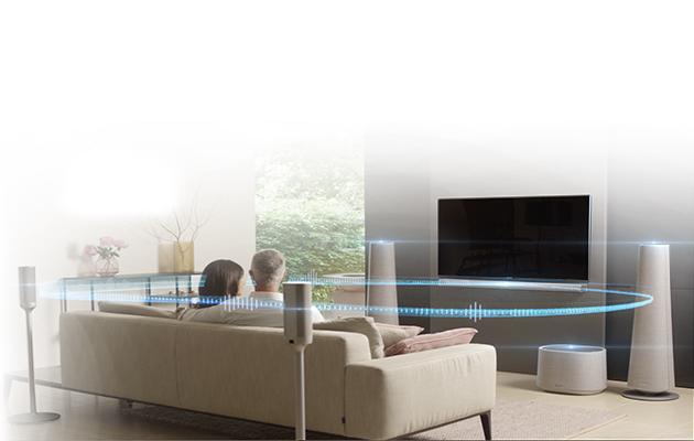 Oplev ægte hjemmebiograflyd uden kabler Par som ser TV med surroundanlæg fra Harmon Kardon