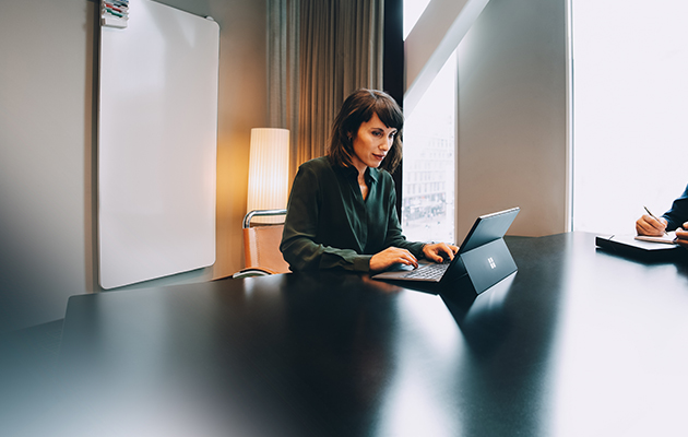 Brug Surface Pro 7 på din måde Kvinde som sidder i en sofa og bruger en Surface Pro 7