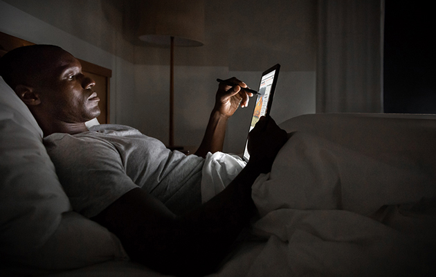 Surface Pro 7 er en kraftfuld enhed, som booster dine idéer Mand som ligger i en seng og bruger Surface Pro 7