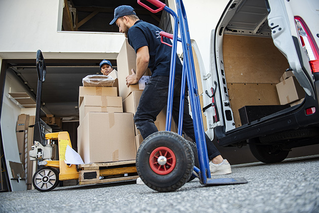 Transportere hvidevarer hjem Folk som leverer tunge kasser fra en varebil.