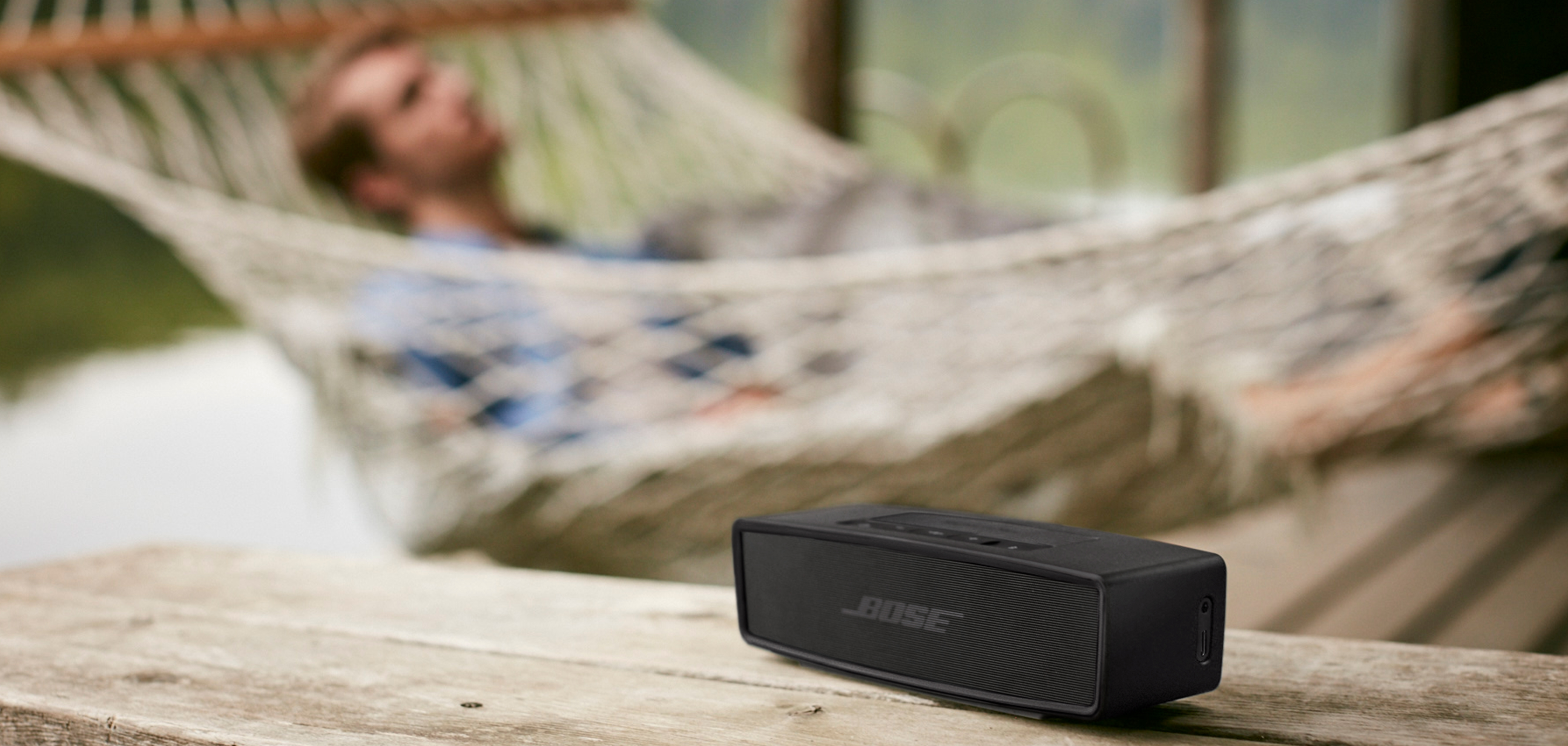 Bose SoundLink Mini Bluetooth® speaker II Bose SoundLink Mini Bluetooth® speaker II med mand i hængekøje i baggrunden