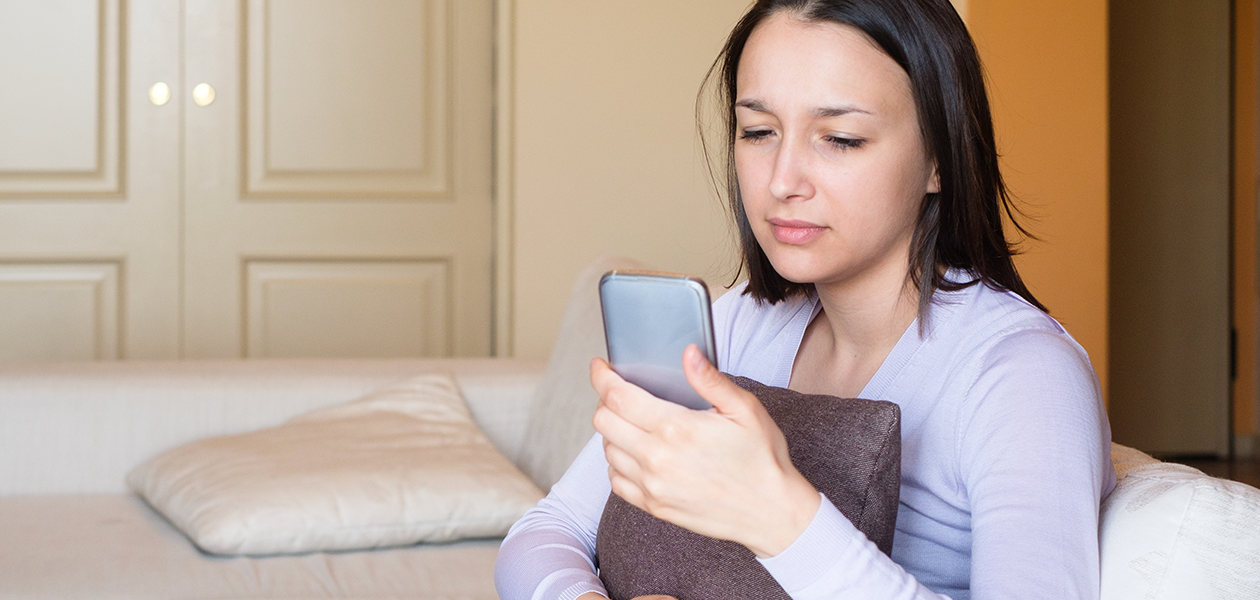 Hold din telefon beskyttet mod virus og malware Kvinde ser trist på sin telefon