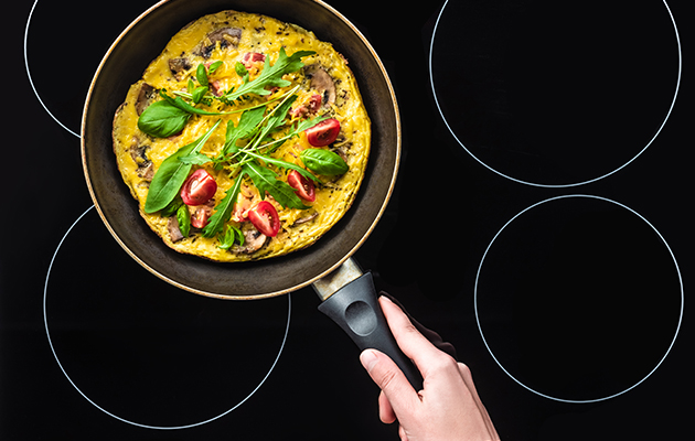 Keramisk kogeplade En omelet i en stegepande, som står på en kogeplade