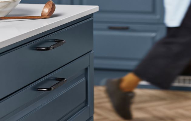 Nyheder inden for fronter fra Epoq, der følger den aktuelle køkkentrend Køkkenlåge fra Epoq af typen Heritage Blue Grey; en person går i baggrunden