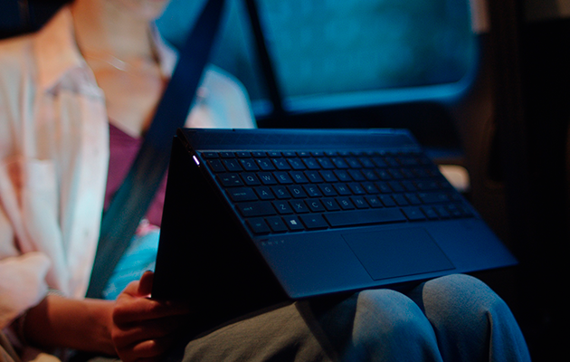 2-i-1 Kvinde bruger en 2-i-1 HP Envy X360, mens hun sidder i en bil