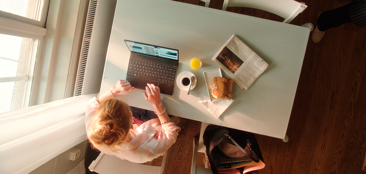 Hvilke funktioner har den bedste bærbare computer Kvinde sidder ved Cafe med en HP Envy X360