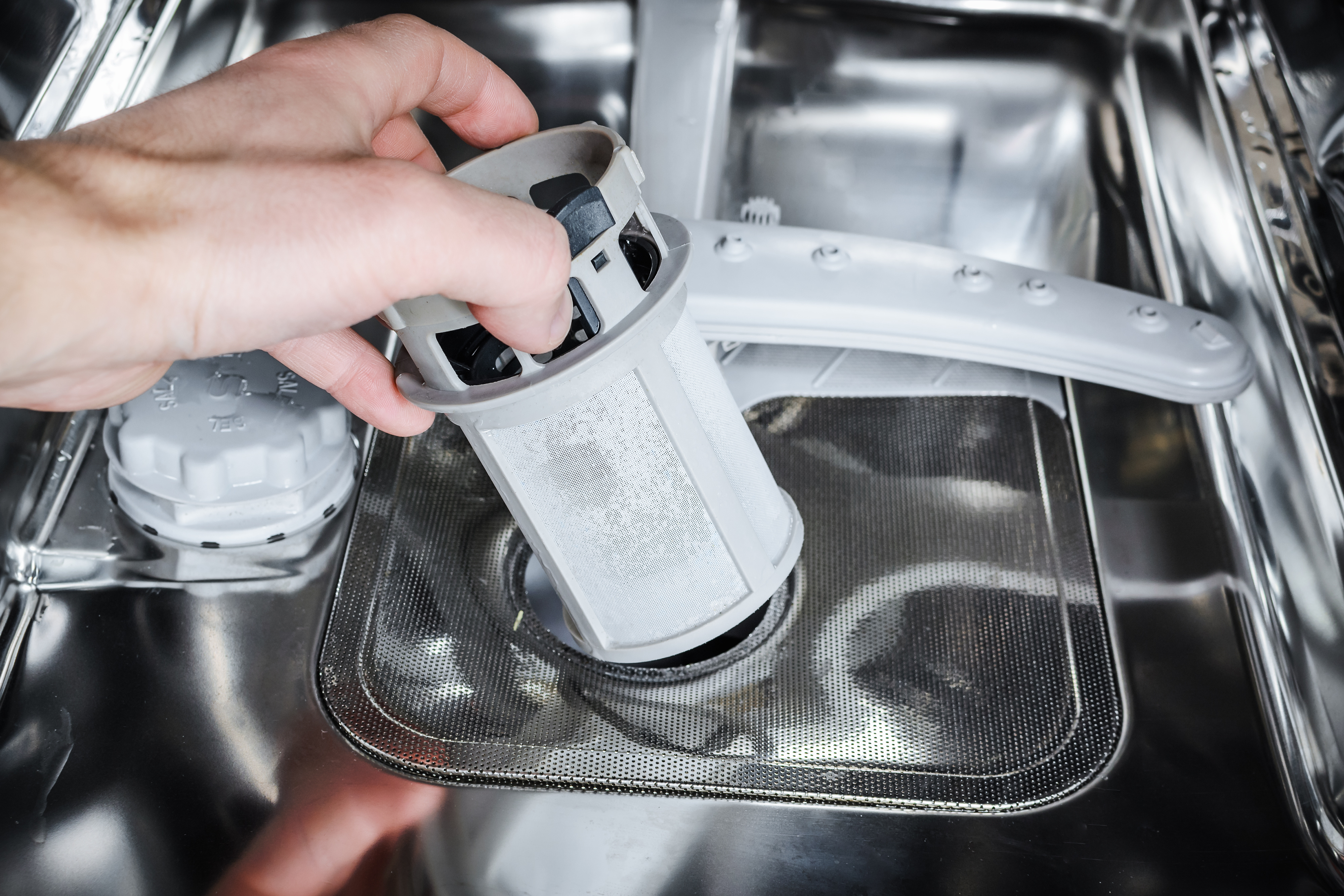 Forebyggelse er den nemme løsning En hand holder opvaskemaskinens filter