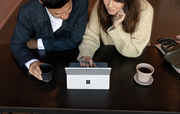 Surface Go 2 kan klare alle punkter på dagsordenen Kvinde og mand sidder med Surface Go 2