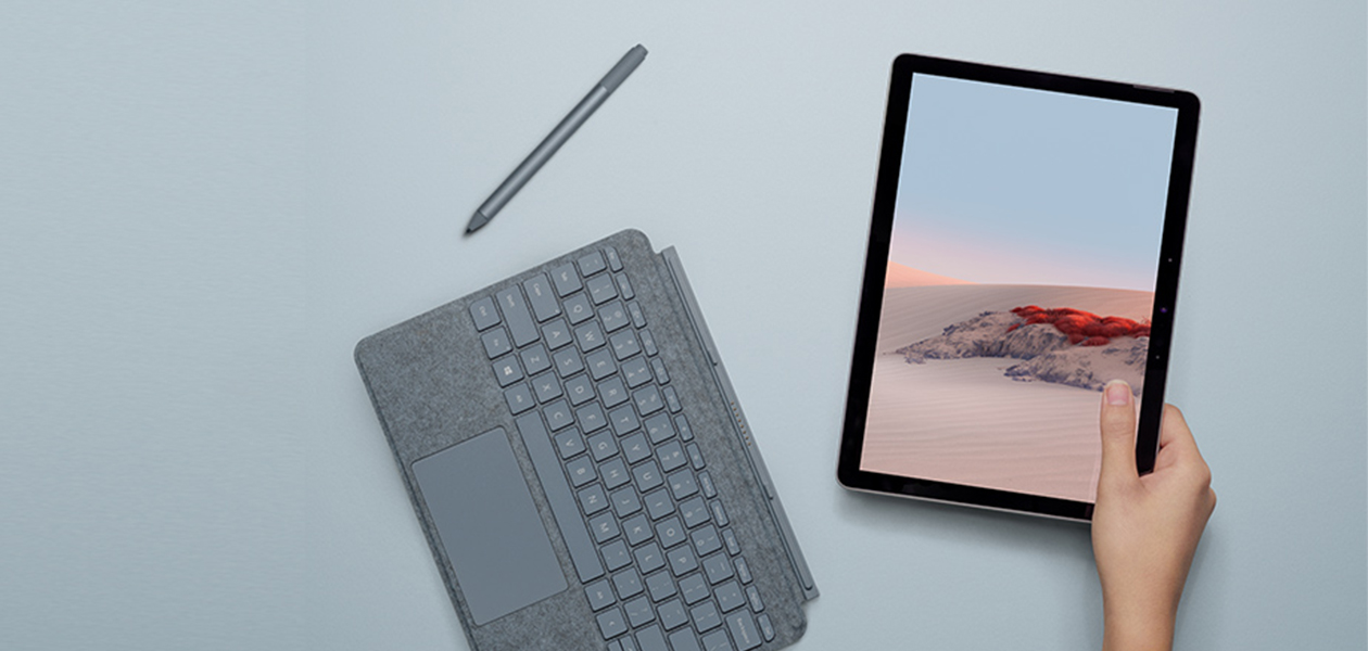 Surface Go 2 er bedst som bærbar Surface Go 2 sammen med Surface Pen og Type Cover på blåt bord