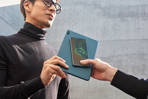 Løb aldrig tør for strøm Mand holder Huawei MatePad Pro og oplader anden persons telefon