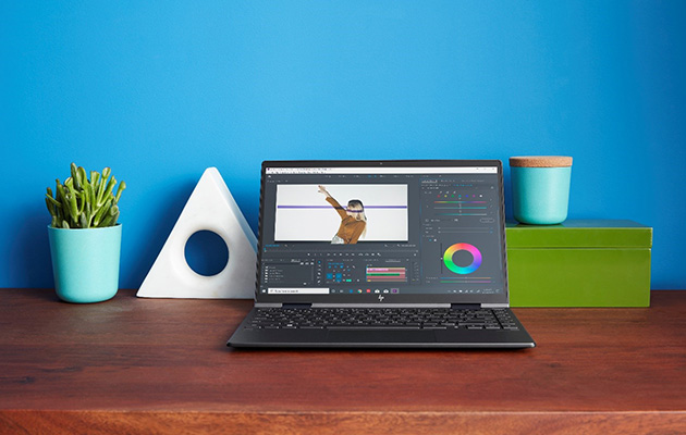 HP Envy x360 – utrolig lyd HP Envy x360 på et skrivbord foran en blå væg
