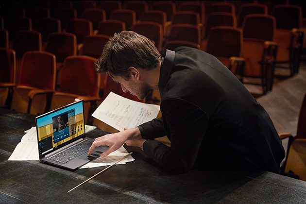 Lenovo Yoga Slim 7 har utrolig lyd og billede Mand arbejder på Lenovo Yoga Slim 7 med noder i hånden