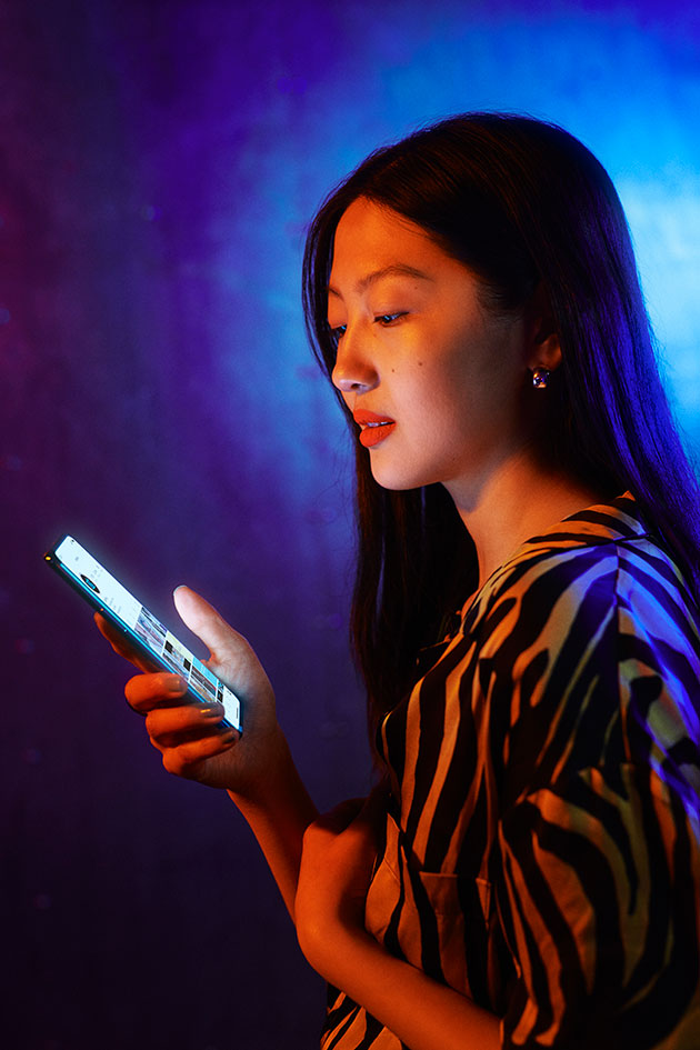 Oplev mere på den store AMOLED-skærm OnePlus Nord med lysende skærm i hånden på kvinde i neonbelyst rum