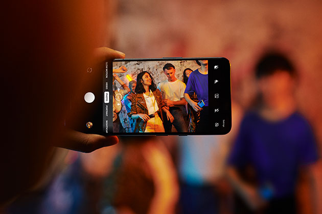 Skærmen leverer en flot visuel oplevelse med opdateringsfrekvens på 90 Hz OnePlus Nord i hånden på person, der tager et billede af en lille gruppe folk