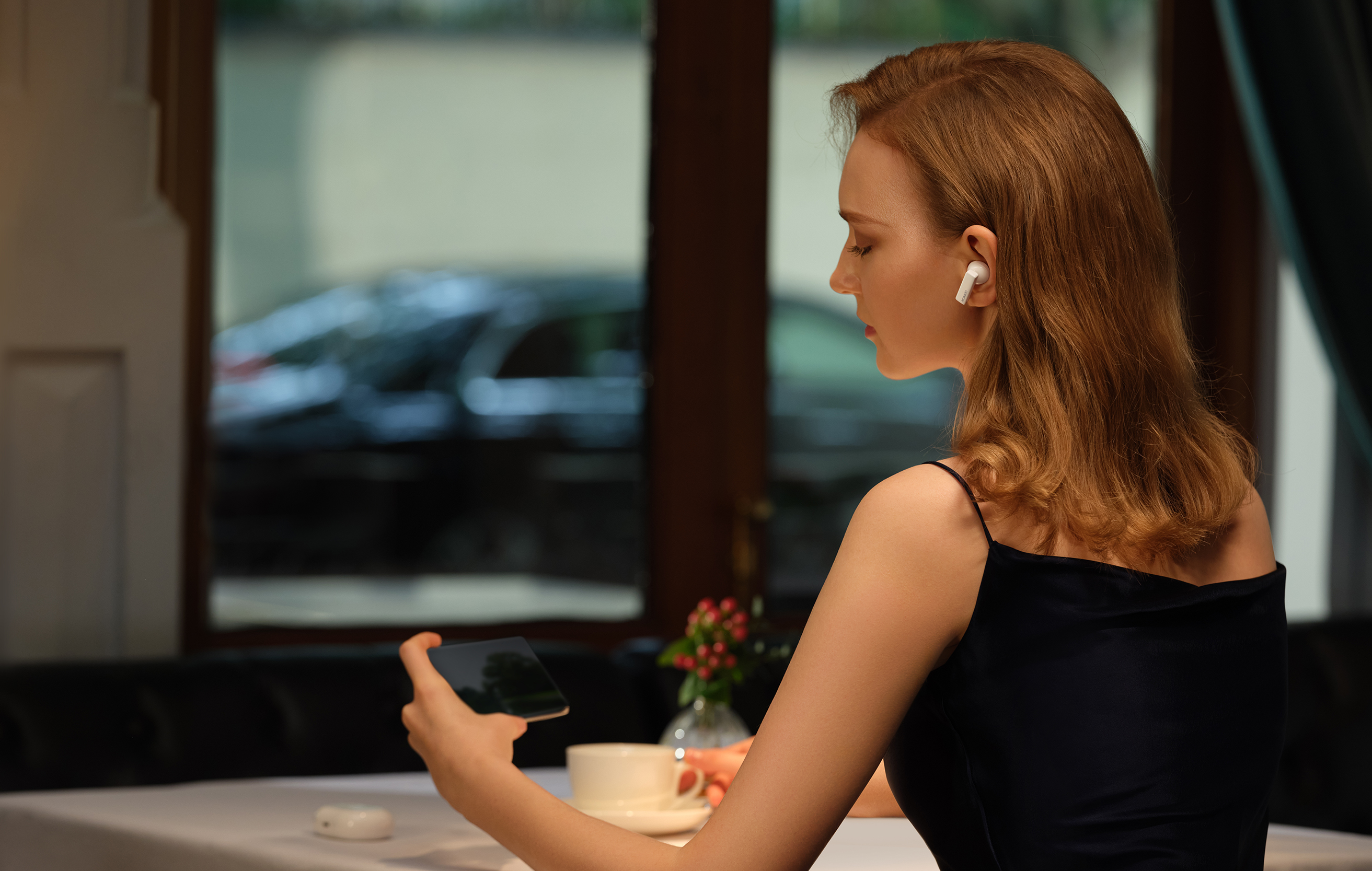 General Mode reducerer støj fra omgivelserne Kvinde med HUAWEI FreeBuds Pro på restaurant