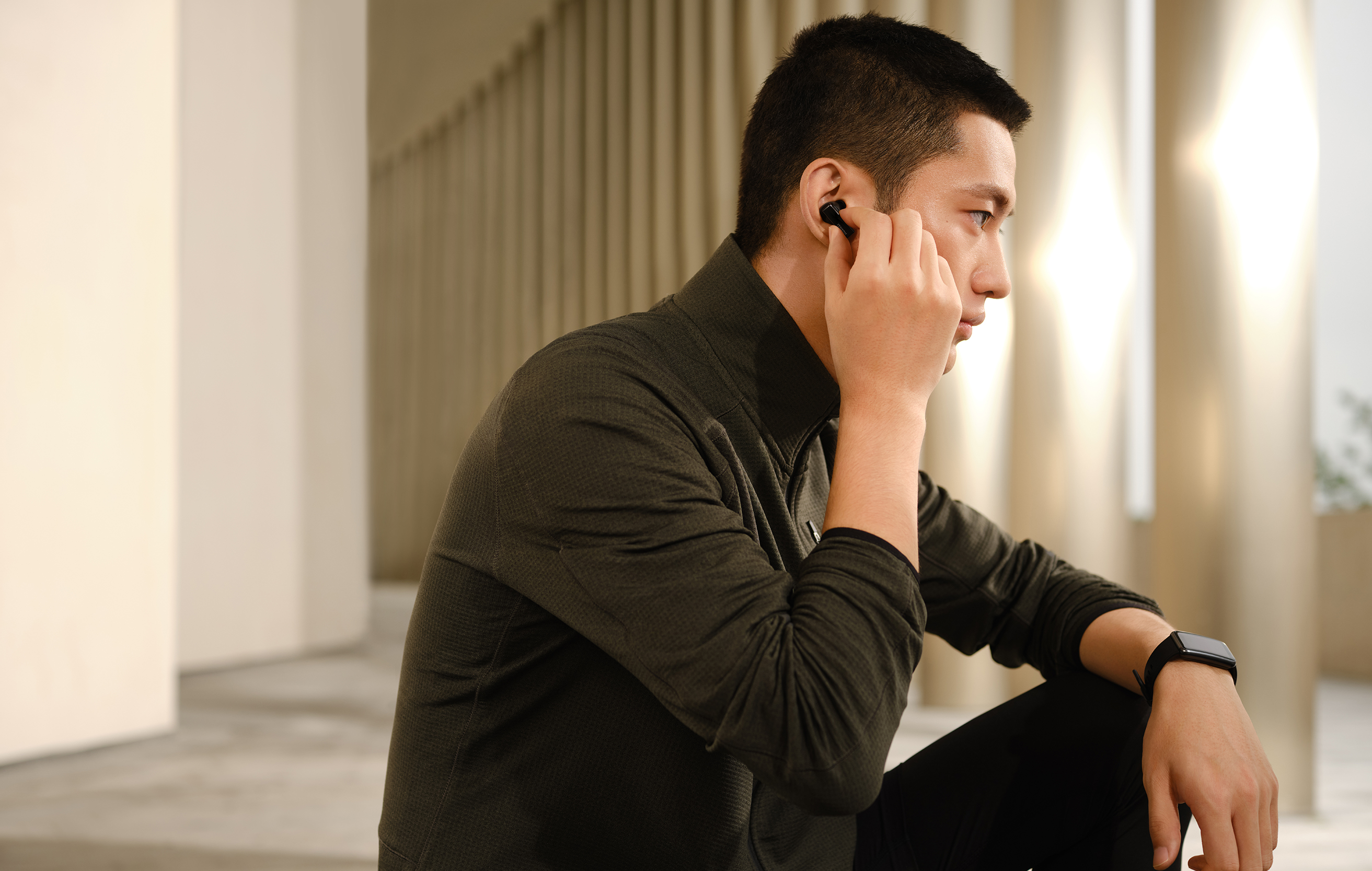 HUAWEI FreeBuds Pro er helt trådløse hovedtelefoner med dynamisk, aktiv støjreduktion Mand som sidder med HUAWEI FreeBuds Pro