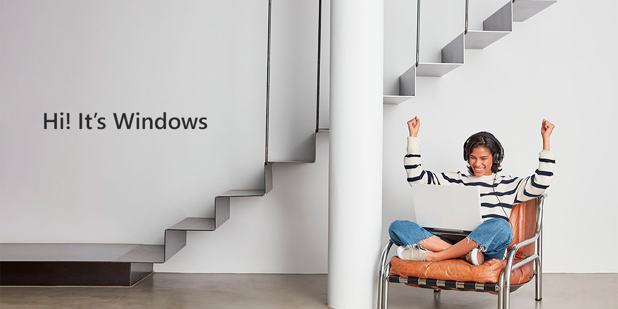 Windows – flere måder at arbejde på Kvinde sidder i stol med computer i skødet og armene i vejret
