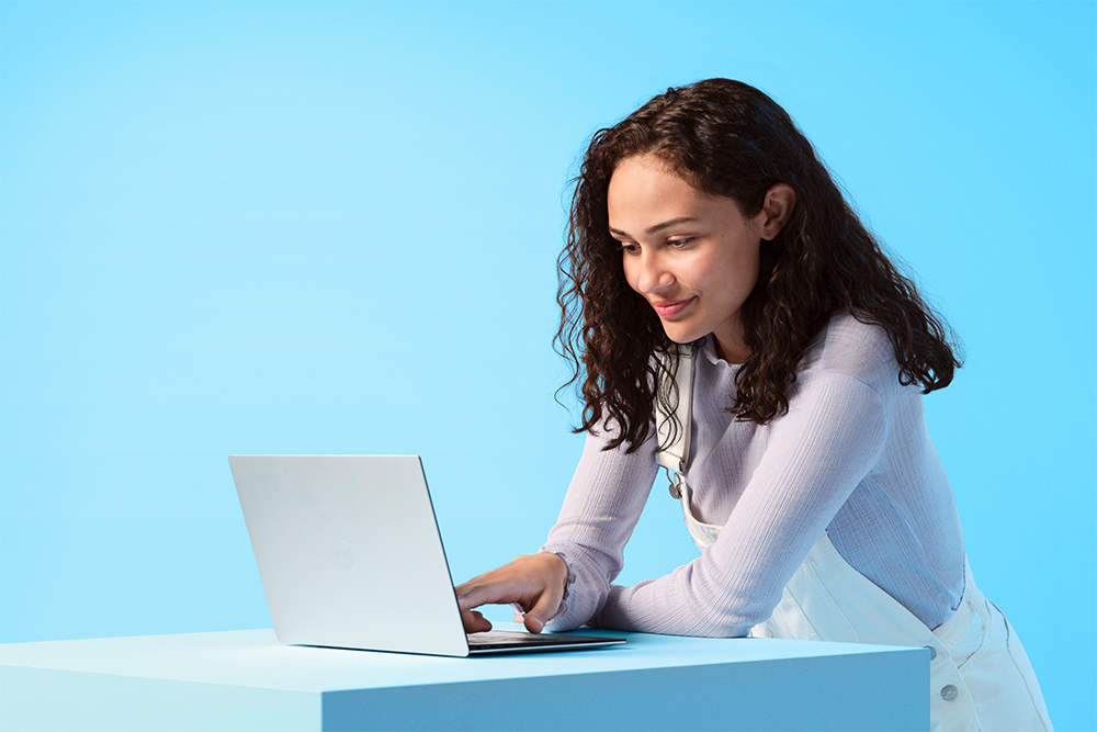 Windows 11 lader dig maksimere din produktivitet Kvinde står med en Windows 11-computer foran sig