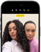 Sort iPhone 18 Pro vist forfra, mens det viser to modeller, der poserer foran kameraet for at demonstrere Center Stage-kameraet på forsiden