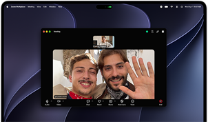 Sølvfarvet MacBook Pro med PROLED XDR-skærm, skærmen viser et igangværende videoopkald med en solbeskinnet by, hvor to personer vinker til en person derhjemme
