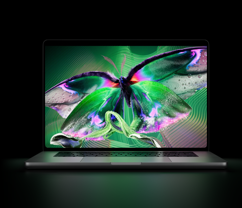 Sølvfarvet MacBook Pro med PROLED XDR-skærm, skærmen viser et detaljeret billede med høj kontrast og levende farver, tastaturet oplyses af skærmen