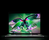 Sølvfarvet MacBook Pro med PROLED XDR-skærm, skærmen viser et detaljeret billede med høj kontrast og levende farver, tastaturet oplyses af skærmen