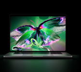 Sølvfarvet MacBook Pro med PROLED XDR-skærm, skærmen viser et detaljeret billede med høj kontrast og levende farver, tastaturet oplyses af skærmen