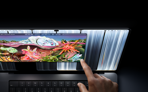MacBook Pro i farven space black med PROLED XDR-skærm, brugeren ændrer størrelsen på et vindue på skærmen med fingrene